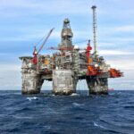 An offshore oil platform in Norway's North Sea under a clear blue sky.